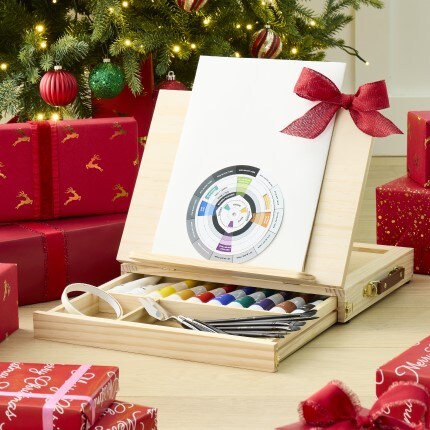 wood easel with bow on it sitting in front of a Christmas tree