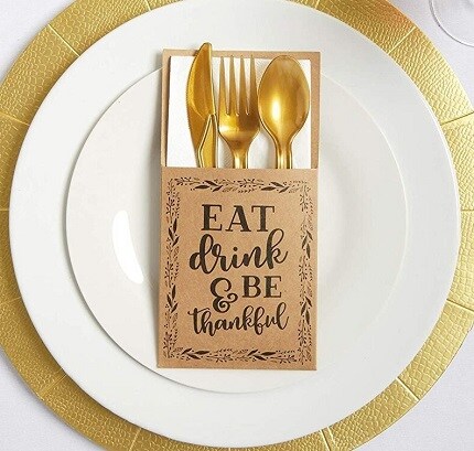 white plate with gold charger and gold silverware in envelope