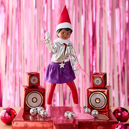 Elf on a stack of presents in the popstar outfit. (The Elf on the Shelf® MagiFreez® Pop Star Set)