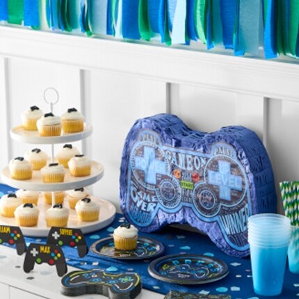 Gamer party decorations with controller pinata and cupcakes