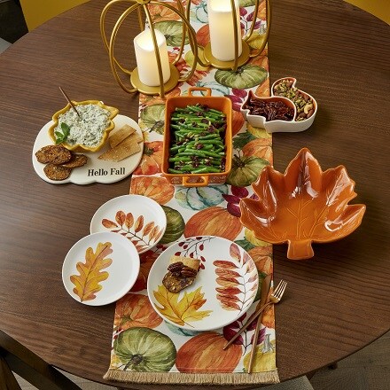 Thanksgiving Party supplies: dinner table with plates fall inspired in orange colors and leaf design