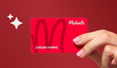 red Michaels store credit card on blue background with Christmas items