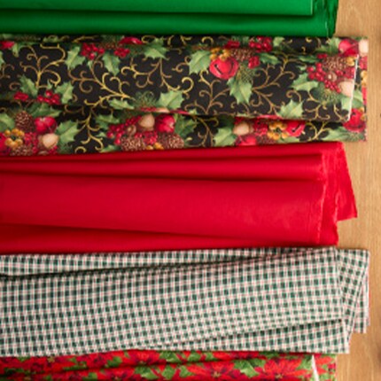 two stacks of winter themed fabrics, one stack in shades of blue the other in shades of red