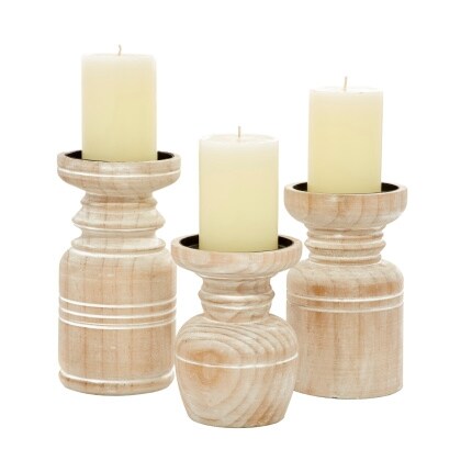 three pillar candles in whitewashed wood holders