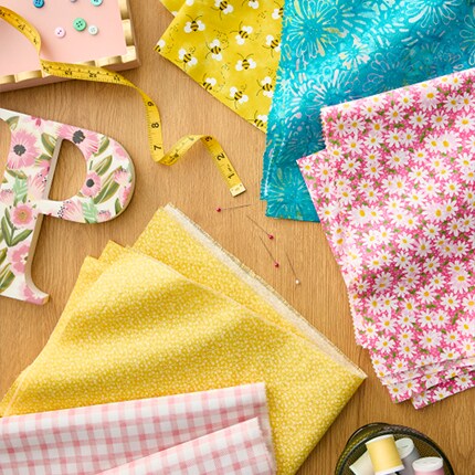 assorted pink, yellow and blue fabric cuts on wood table