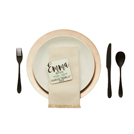 place setting with knife, fork, spoon and plate with napkin and name card