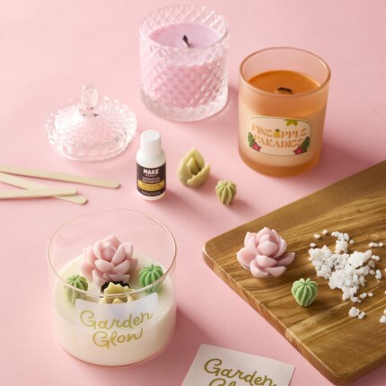 DIY candle making supplies with floral embellishments, scents, and candle jars