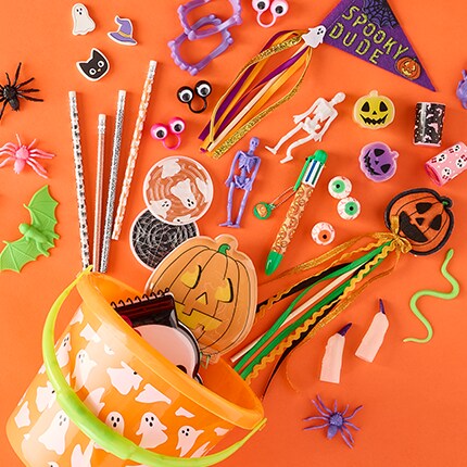 Orange bucket with ghosts. Various toys scattered along an orange background. 