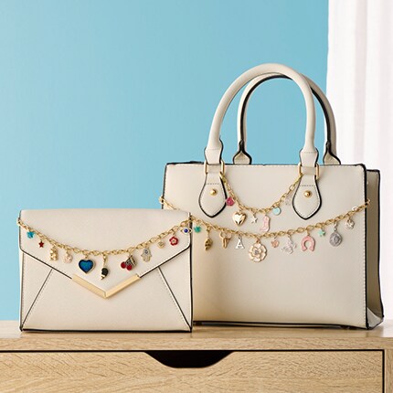 two beige purses with chains and charms