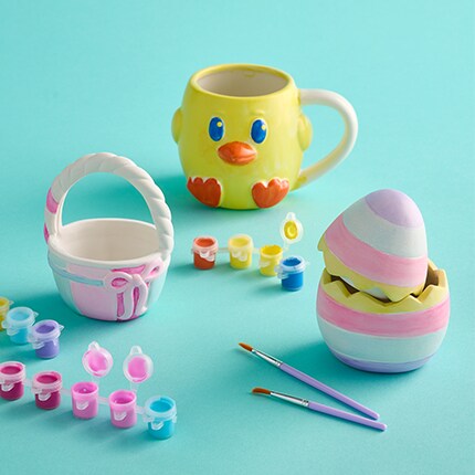 Two pre-drawn canvas, bunny and chick, with a bunny mask and a paint tray sitting next to it. 