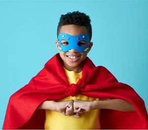 Little boy wearing a cape and a handmade masks