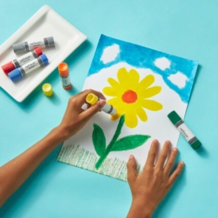 hands using paint sticks to make picture of yellow flower