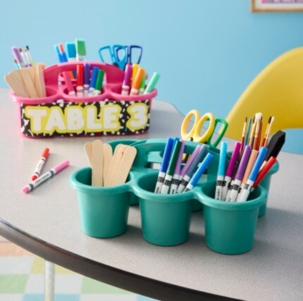 kids art supplies in caddies on table