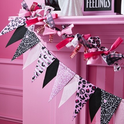 Halloween Decorative Garland in pink and black colors. Garland with ribbon and garland with flags hanging from a mantel.