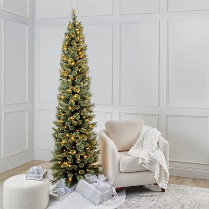 A Christmas tree with lights and presents in a room