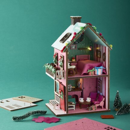 miniature halloween witch room diorama with cauldron, potions, pumpkins, and spooky decorations with purple hazy background