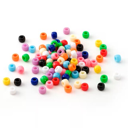 Colorful plastic pony beads in pink, blue, green, orange, yellow, white, and black form a loose pile on a white background, creating a playful scene.