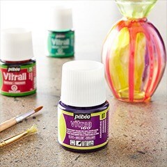 purple and green glass paint bottles on table