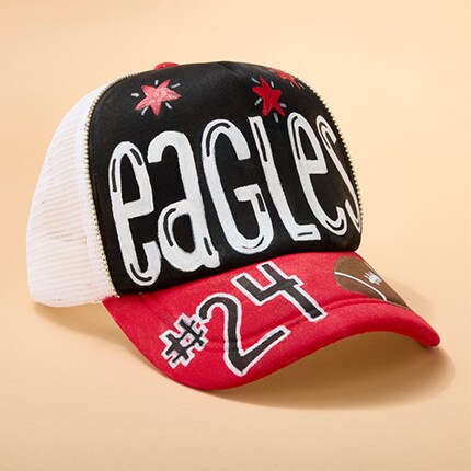 baseball hat decorated with eagles in white letters on black background and red bill with #24