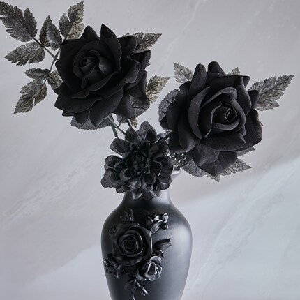 Black Floral Stems in black pots over a tabletop next to a ghost tabletop decoration.