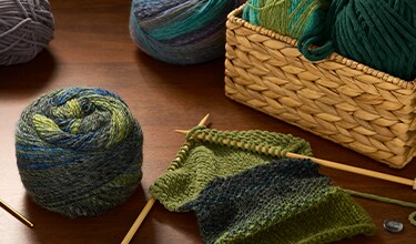 green and blue yarn skeins on a table