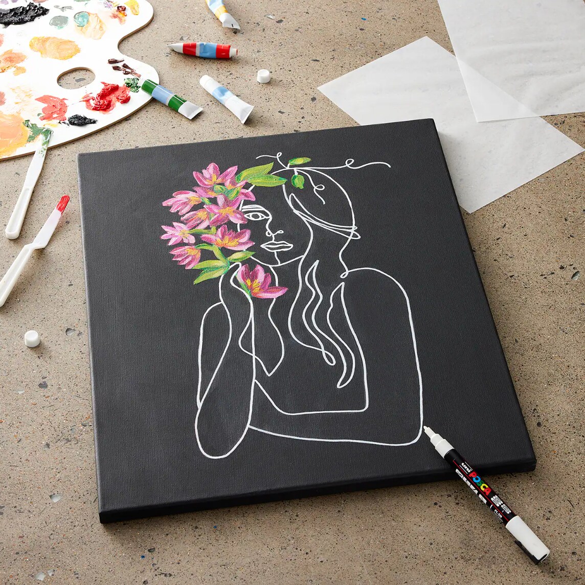 A painting of a woman and flowers on a black canvas