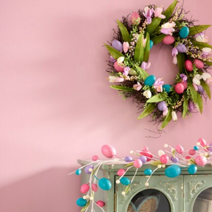 Easter wreath with floral and eggs and egg garland on a mantle 