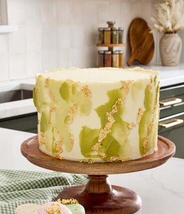 '25 baking reset wooden cake stand w/ green, white, gold icing cake