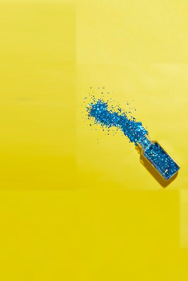 blue glitter jar spilled over on yellow background