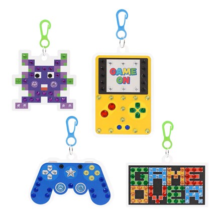 Four colorful gaming keychains show a pixel alien, yellow “GAME ON” handheld console, blue controller, and cheerful retro arcade art.