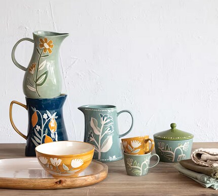 pitchers and tableware in navy, green and yellow on wood table