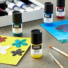 yellow, green, blue bottled paint on table with flower painting