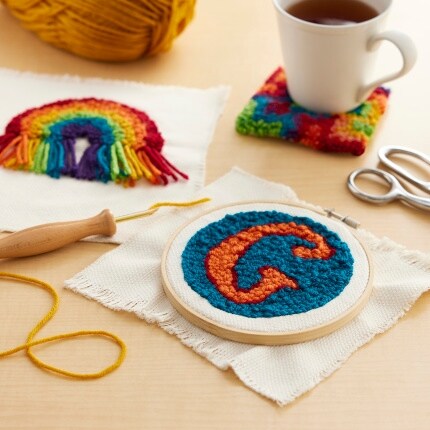 Artisanat de punch needle avec dessous de verre et tasse à café sur la table.