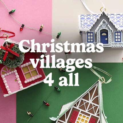 Festive ornaments resembling houses against a pink and green backdrop, decorated with string lights. Text reads "Christmas villages 4 all."