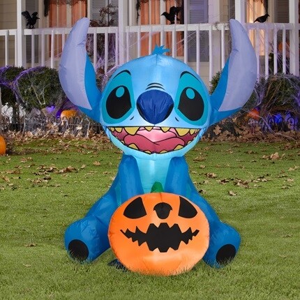 Halloween Stitch inflatable with pumpkin in a yard.