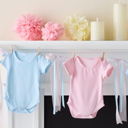 blue and pink onesies handing from mantel