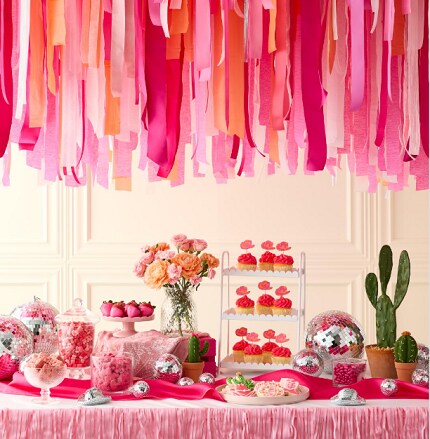 assorted glass vases with pink candies on pink tablecloth