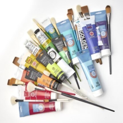 Assorted paint and paint brushes laid out 