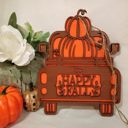 MakerPlace by Michaels Wooden sign shaped like a vintage truck with a pumpkin and "Happy Fall" text. Surrounded by autumn decorations, conveying a festive and cozy vibe.