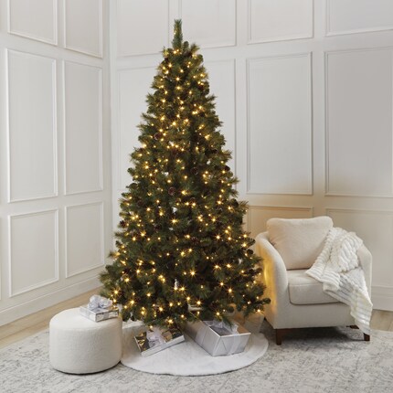 A Christmas tree with lights and presents in a room