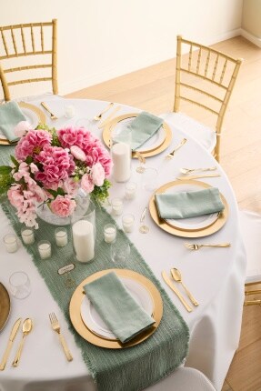 green and gold wedding table with gold chairs and pink flowers