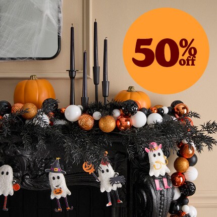 dark purple room with Halloween decorated mantle and hanging black candles