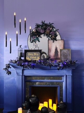 dark purple room with Halloween decorated mantle and hanging black candles