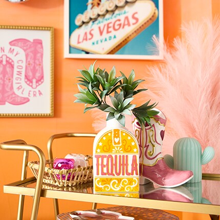 tequila vase on cart with western and las vegas wall art on orange wall