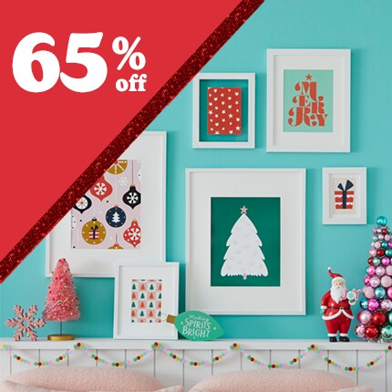 teal wall with white holiday frames and red triangle with 65% off in white text