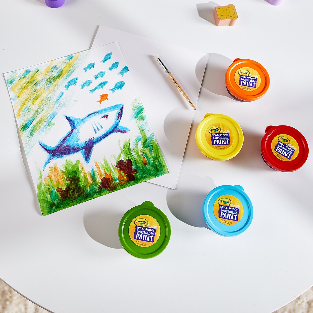 Crayola paint trays around a painted shark. 