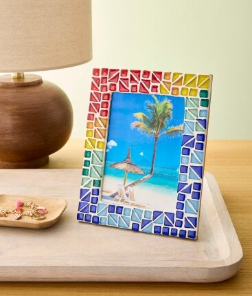 mosaic frame with tropical photograph on table