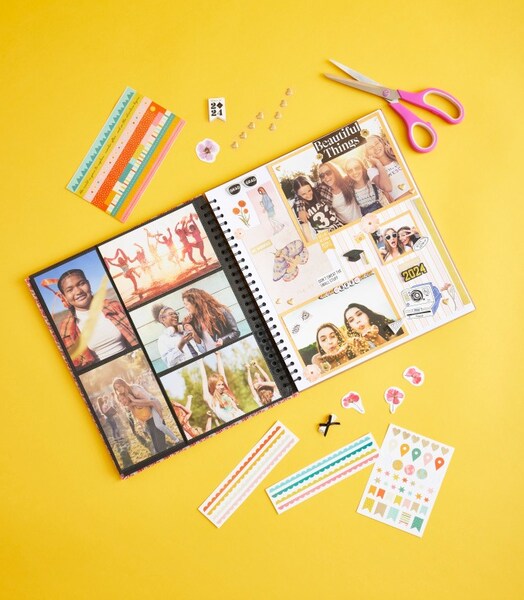 Scissors and stickers surrounding a scrapbook.