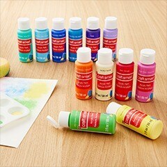 Multiple colors of paint bottles on table