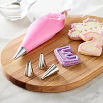 A frosting decorating set rests on a cutting board.